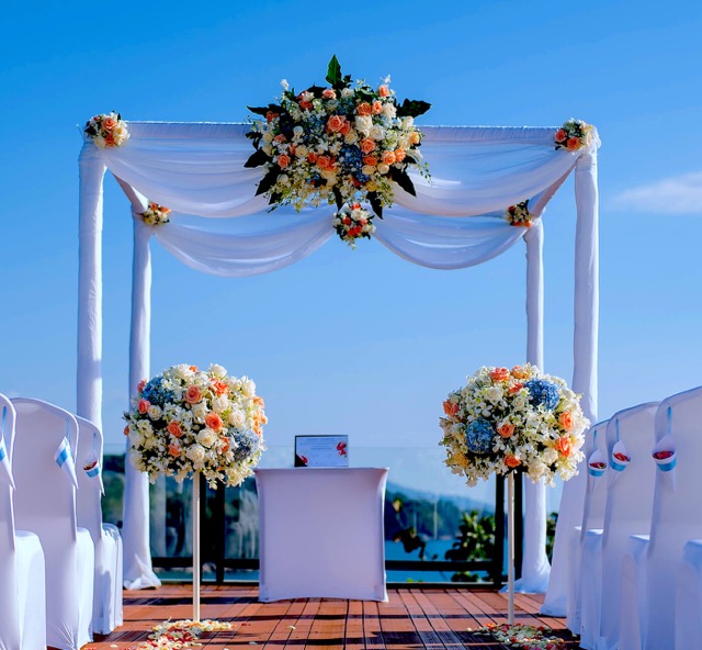 This is well constructed chuppah, save for the two stands with coloured flowers which could easily be knowcked over by anyone making thier way under the canopy. It is also better not to have audio speakers at the front.
